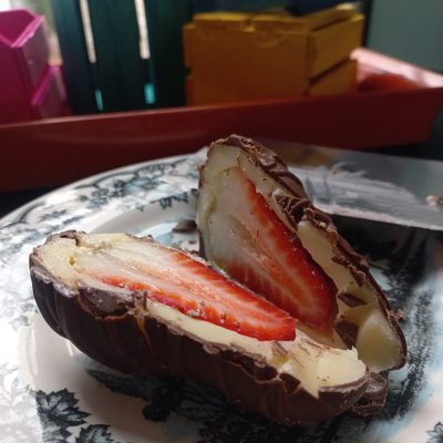 Bombom de chocolate cortado, com morango e creme dentro