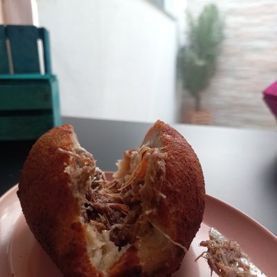 Sonho aberto ao meio mostrando o recheio de creme